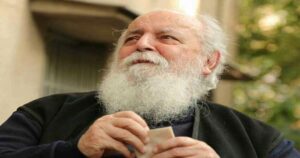 جناب هوشنگ ابتهاج با لباس های مشکی و ریش و موی سفید که دارن به دور دست نگاه میکنن