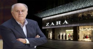 آمانسیو اورتگا با ست رسمی با کت شلوار و در پشتش تصویری مغازه ایی از zara