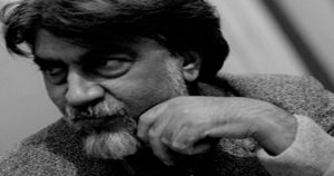 تصویری از قیصر امین پور{تصویری از مردی با ریش سفید و موهای جوگندمی تصویری سیاه و سفید که دارد به سمت چپ نگاه میکند}